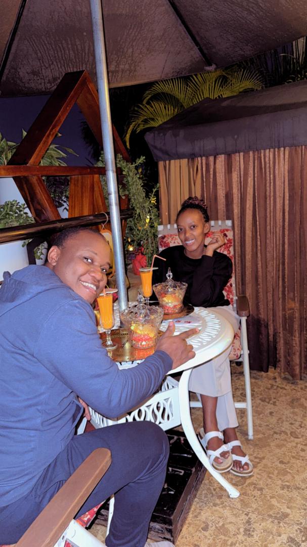 Brian and Angella at a candlelit outdoor table with drinks between them
